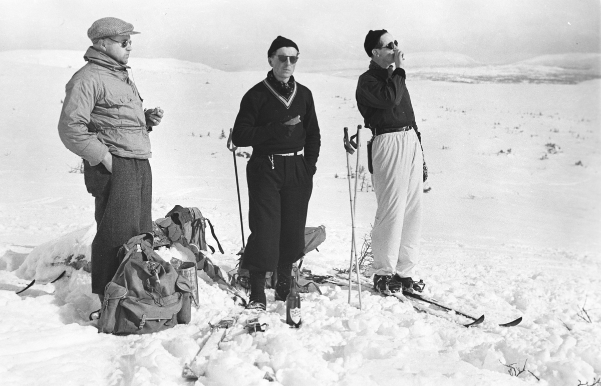 Tre menn på ski tar pust på påsketuren. Fotografert 1940.