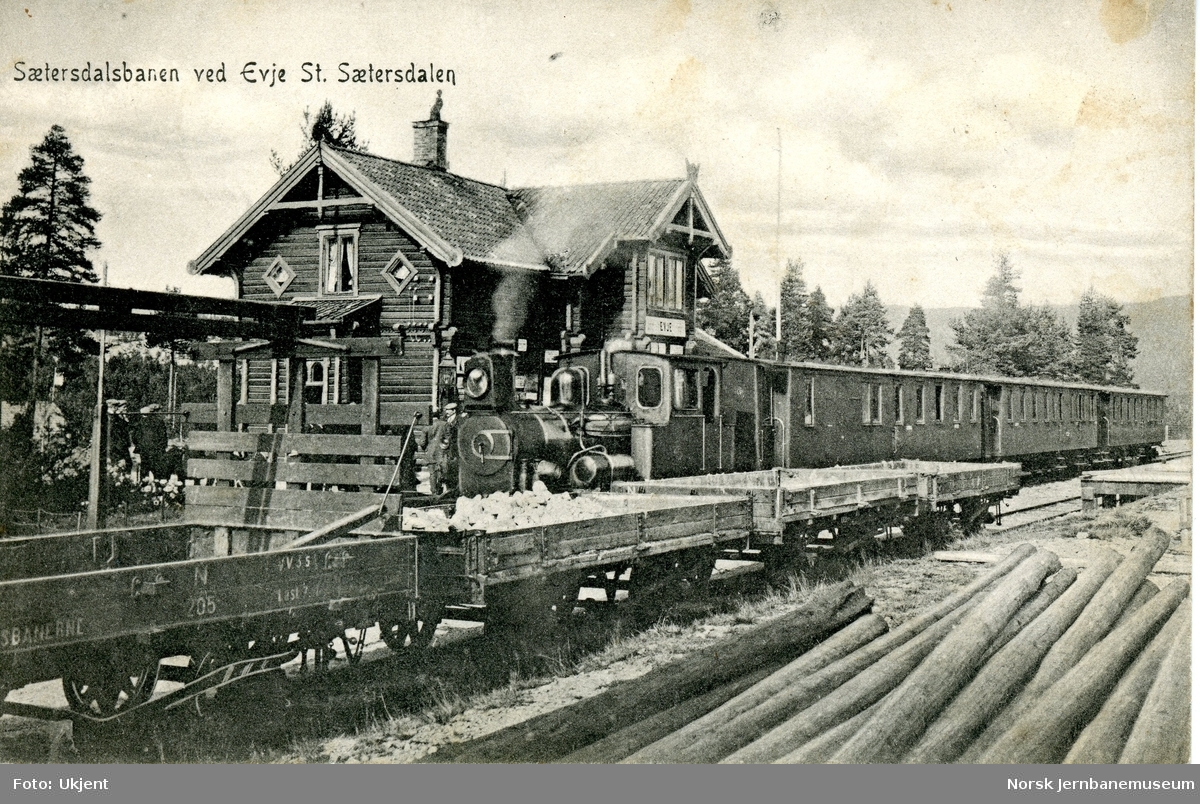 Damplokomotiv med persontog på Evje stasjon på Setesdalsbanen. I forgrunnen godsvogner litra N og M
