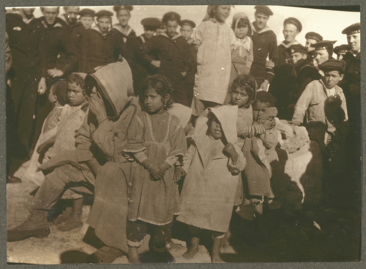 Bilden visar Fylgias besättning som har samlats rund en grupp barn.