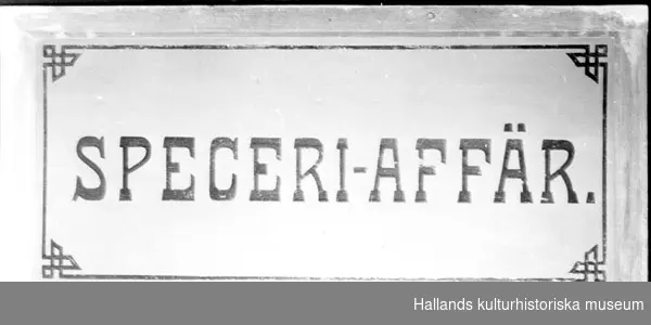 Fönster av matt glas med ram av furu. Utsparad dekorativ brun ram. Märkt: "SPECERI-AFFÄR". Längd: 123 cmBredd: 59,5 cm.