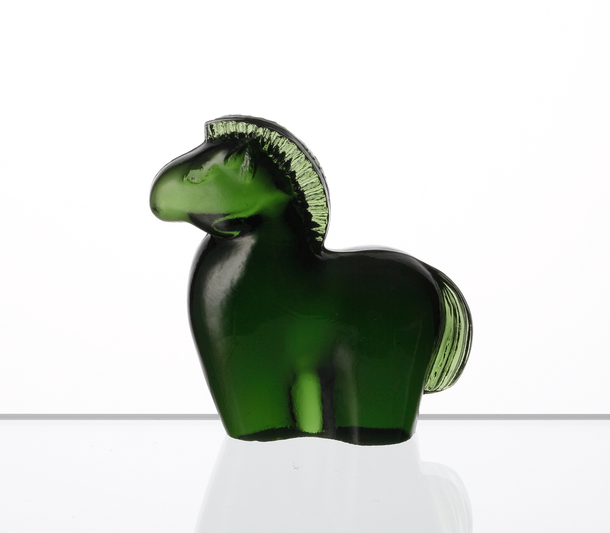 Formgiven av Kjell Blomberg. Mindre figuring i grönt glas, föreställande en häst.
