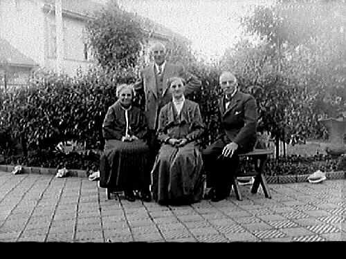 Fyra personer i fotograf Mathilda Ranchs trädgård i kv Bagaren, från vänster: Mathilda Ranch, hennes bröder stenhuggeriägare Erik Ranch och köpman Wilhelm Ranch samt Maria Bäckström.