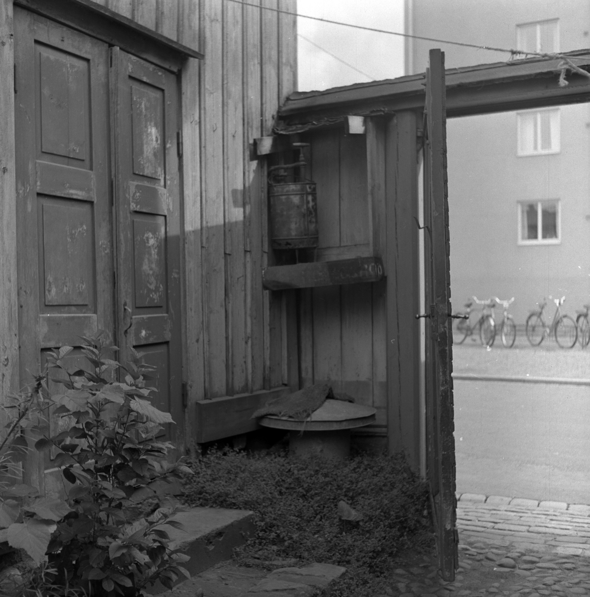På en hörnhylla på insidan av ett gårdsplank står en brandspruta, Jönköping.