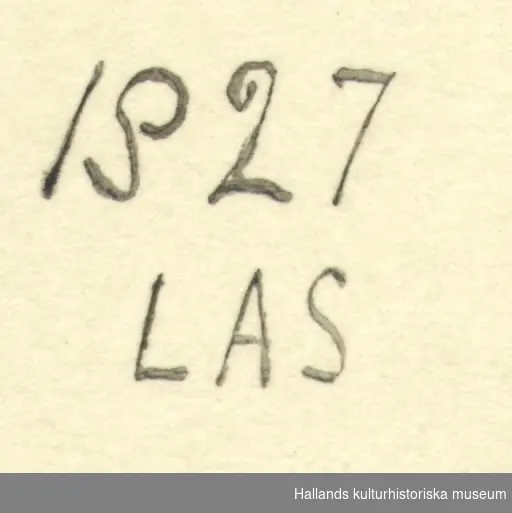 Ask med skjutlock, rikt dekorerad i karvsnittsteknik. På locket är asken märkt "LAS" och på kortsidan "1827". På sidorna ristning i form av kryss, X.