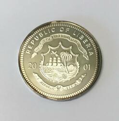 En liberiansk mynt fra 2001 pålydende 25 dollars. Dette er myntens advers med et segl-lignende dekor i midten og Republic of Liberia rundt.