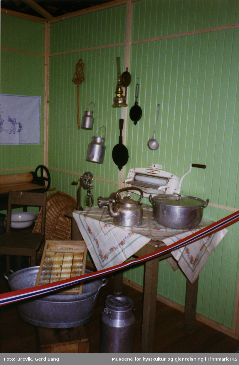 Bildet viser en del av Frigjøringsutstillingen i bystyresalen i Hammerfest som ble vist frem fra 6. juni til 10. august i 1995.
I utstillingen var det iscenesatt noen mindre rom med gjenstander og utstillingsdukker. Dette rommet fremstiller et brakkekjøkken i gjenreisningstiden.