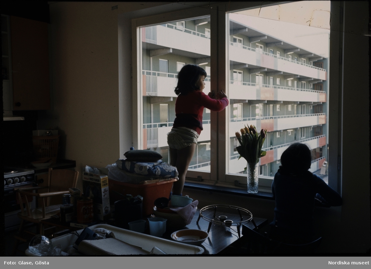 Husby Akalla. Första inflyttningen på Järva. Barn står i köksfönstret och tittar ut.
