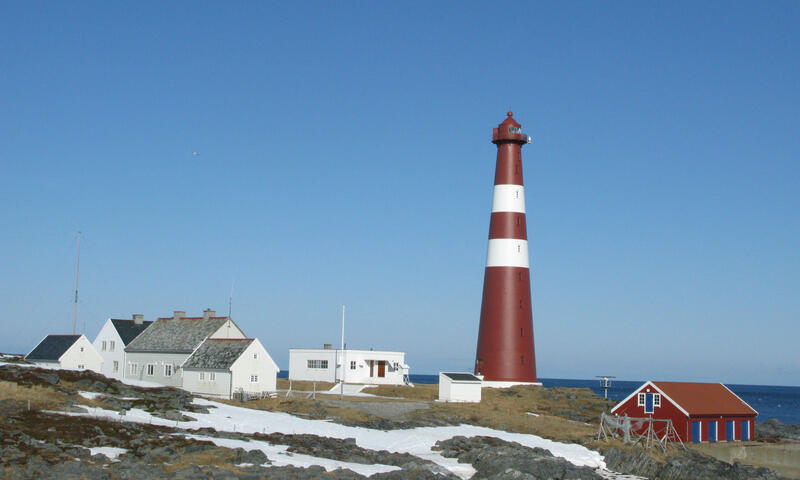 Slettnes fyr mot en blå himmel, sett fra avstand.