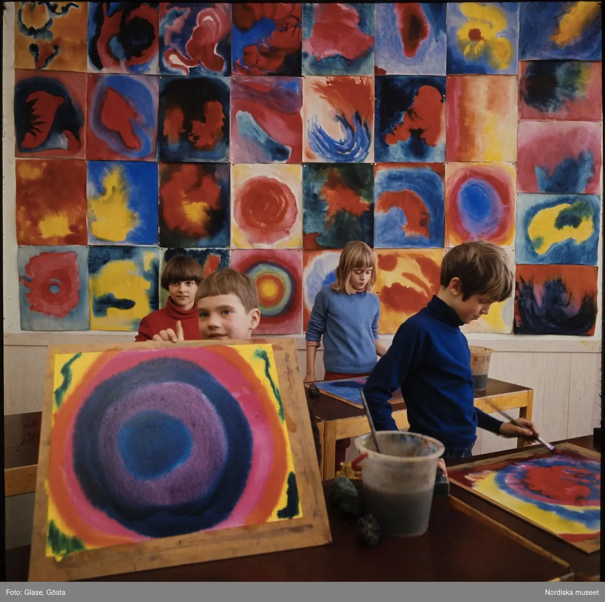 Teckningslektion på Kristofferskolan. Ett barn visar upp sin målning.