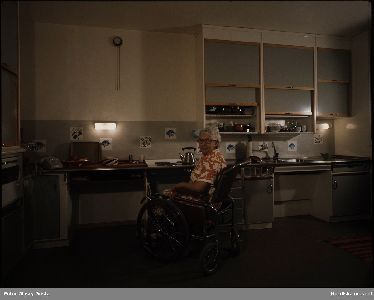 Orminge. Handikapp. En äldre kvinna i rullstol i ett kök.