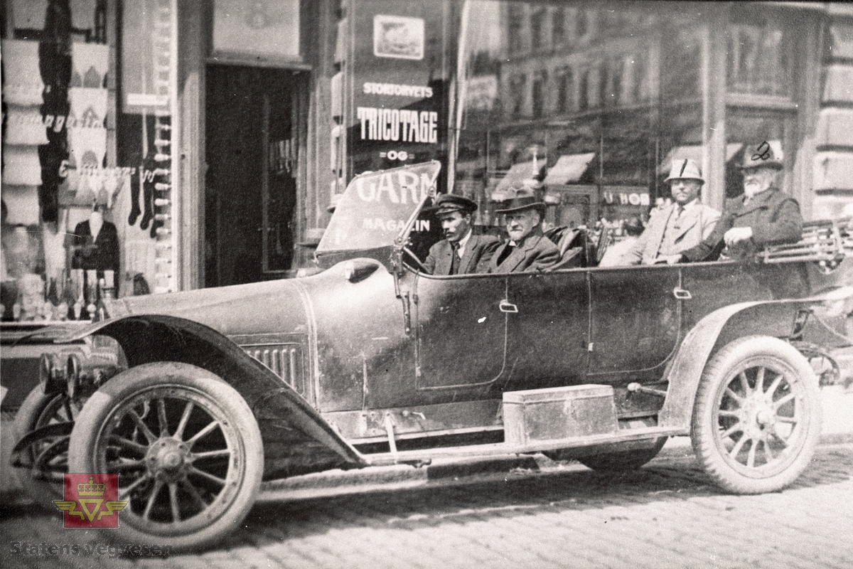 Truleg nokre av skiparane av Indre Automobilselskap A/S i Kristiania (Oslo) på bilkjøp. I baksetet sit hotelleigar Per J. Ness og  gardbruker Erik K. Foss.
02.01.2023: Dette er en Minerva som opprinnelig tilhørte statsråd Chr. Mathiesen, Linderud. Bilen var da registrert på C-6. Bilen har chassis nr. 13149 og den har 26 hk. 
Sannsynligvis innkjøpt i 1913 eller 1914. 
A/s Indre Sogn Automobillag kjøpte bilen i 1919. Den fikk da reg. nr. C-3. (Opplysninger fra Trygve Krogsæter)