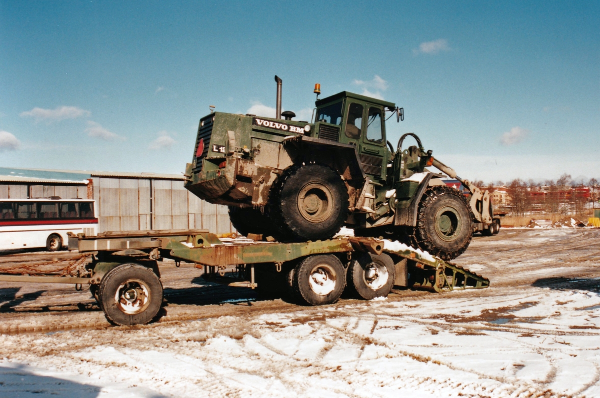 Fältmässig lastning av bandvagn 206 för landsvägstransport i slutet av 1990-talet. Hjullastaren behövs för att bygga tillfälliga lastramper.