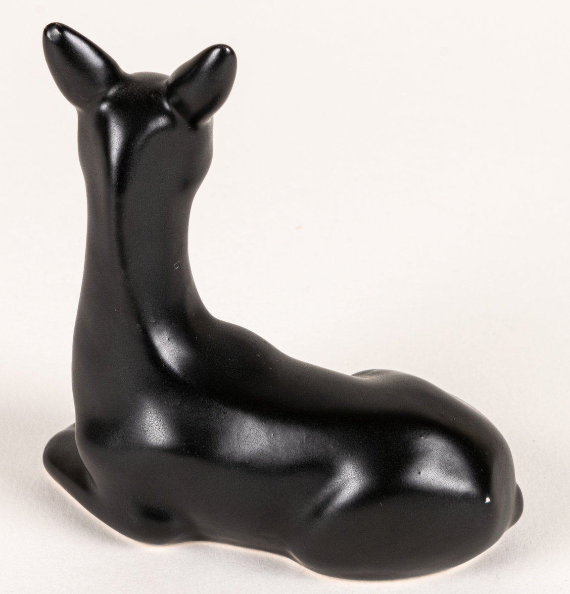 Figurin, svart mangania, föreställande ett liggande rådjur.