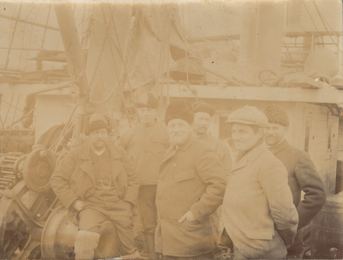Fotografi från första svenska Antarktisexpeditionen 1901-1904. Motiv av expeditionsdeltagare ombord på fartyg. Mannen i mitten längst fram är Otto Nordenskjöld.