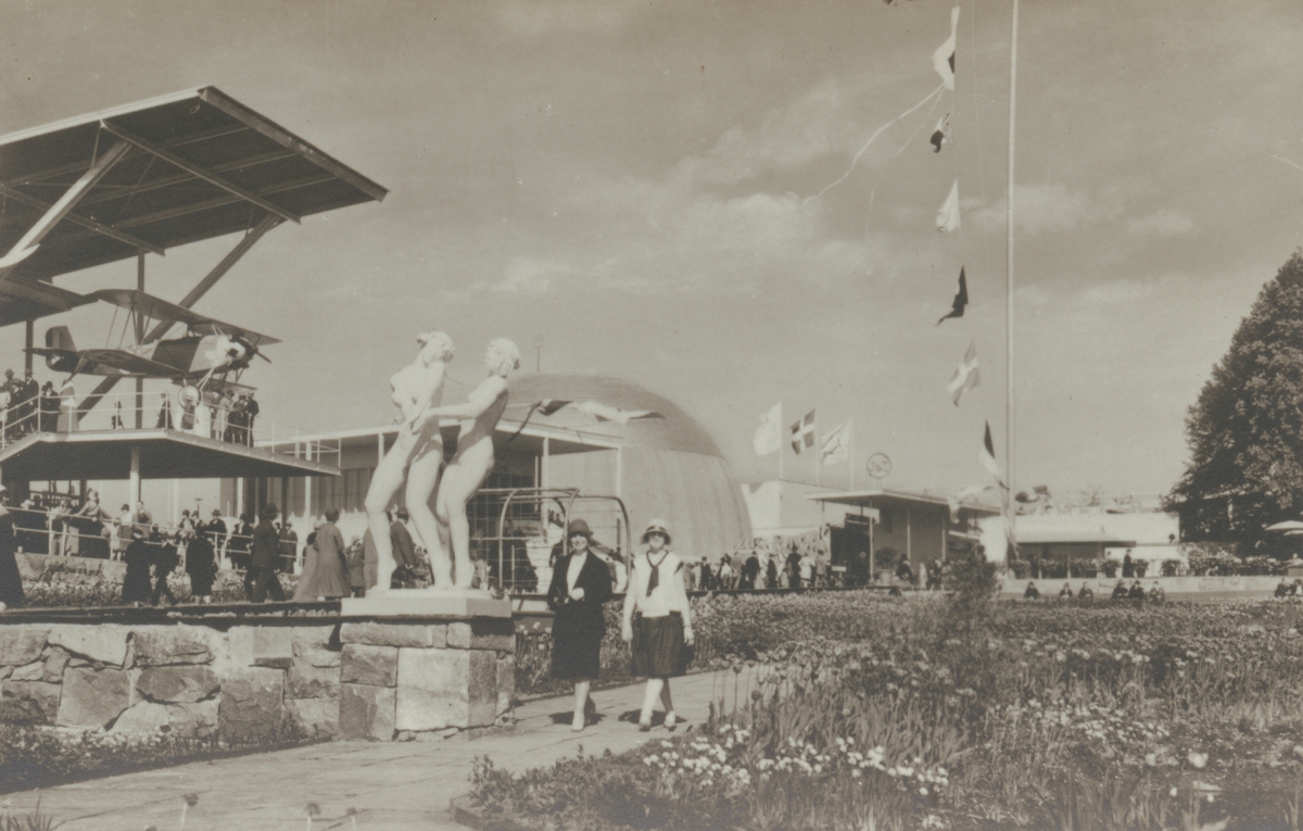 Fotografi från Stockholmsutställningen 1930. Motiv av Alnarpsträdgården, kvinnor och staty.