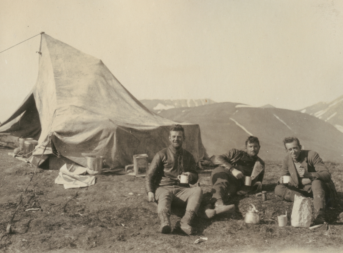 Fotografi från expedition till Sveagruvan. Motiv av tre expeditionsdeltagare som sitter utanför ett tält.