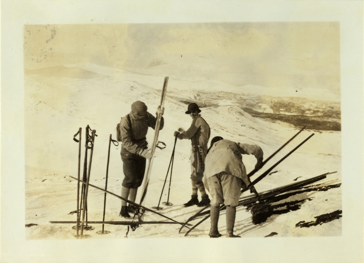 To menn og en kvinne forbereder skitur til Ruten ved Fefor. Mimi eller Lucy Egeberg i midten. Fotografert påsken 1926.