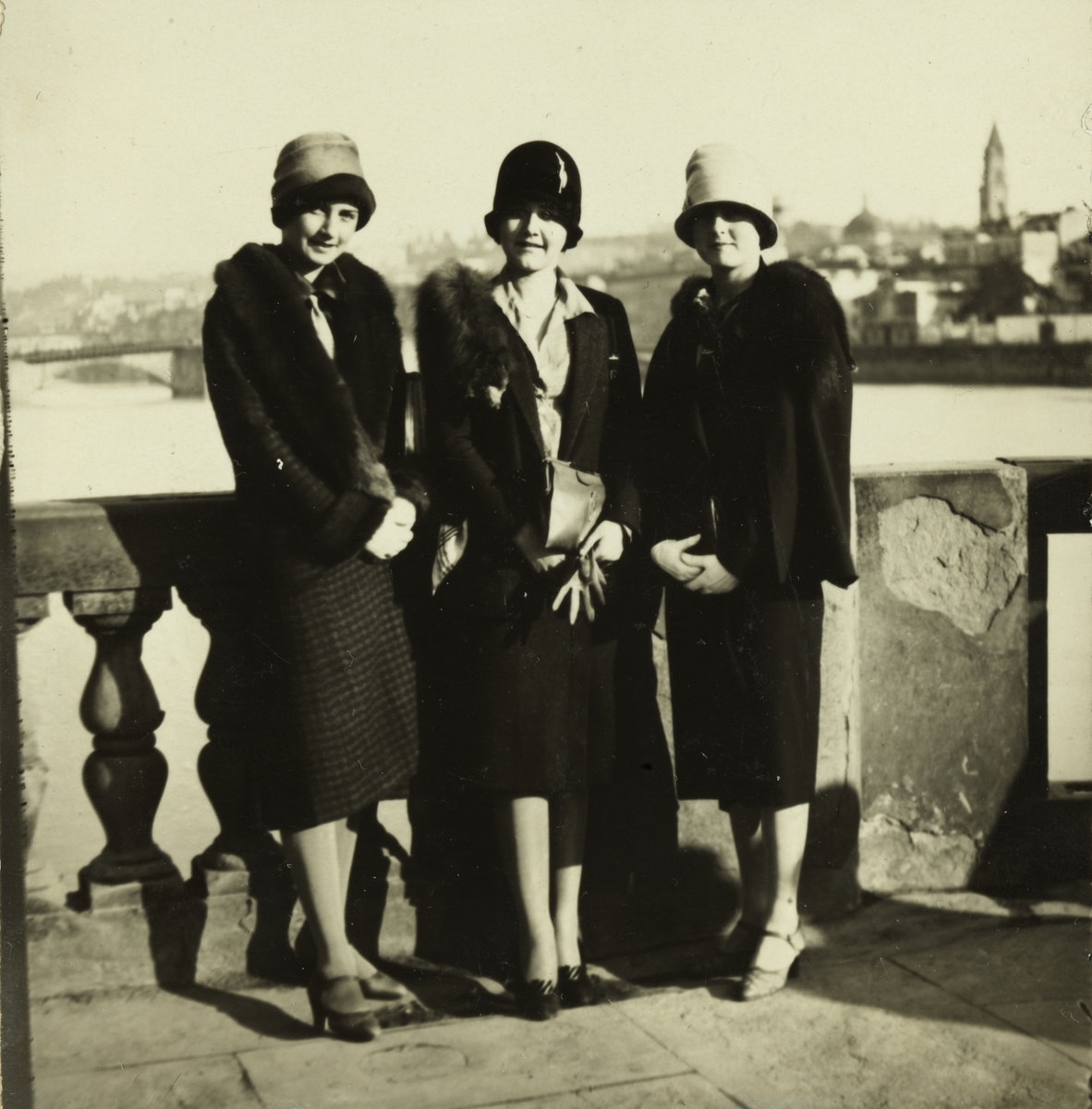 Tre kvinner, antagelig søstrene Mimi, Lucy og Karen Egeberg, på terrassen utenfor hotel Lungarno. I bakgrunnen elven Arno og byen Firenze. Fotografert januar 1927.