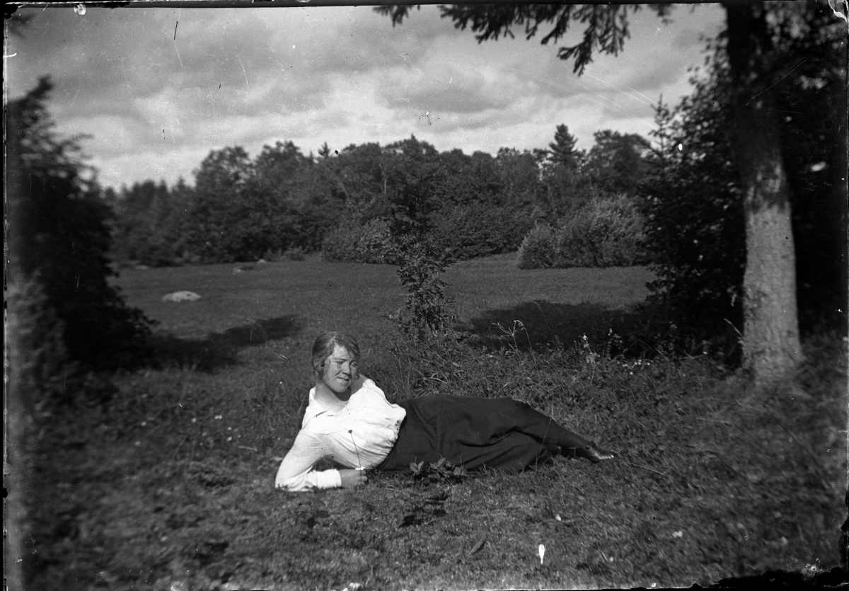 Julia Westergren ligger i gräset.