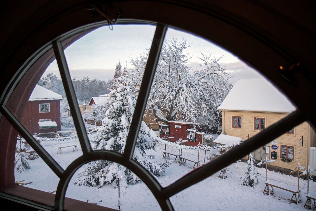 Utsikt genom fönster mot Kryddbodtorget i Gamla Linköping. På torget ser man en julgran. Vinter i Gamla Linköping. December 2022.
