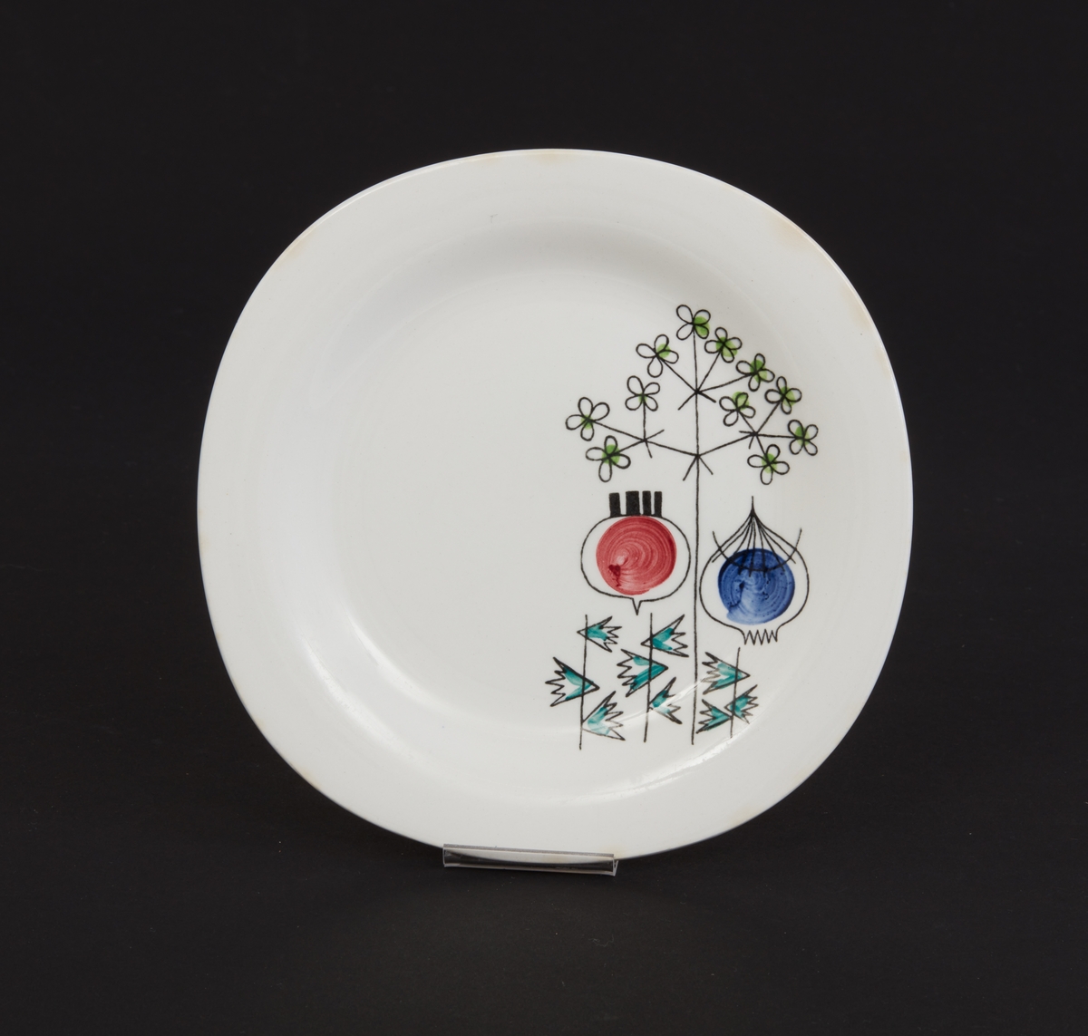 Assiett av vitt porslin. Mönster: "Pomona" stiliserade grönsaker och örtkvistar. Design: Marianne Westman. Stämplad: "Pomona, Rörstrand, Sweden". Tillverkades 1956 - 1971.