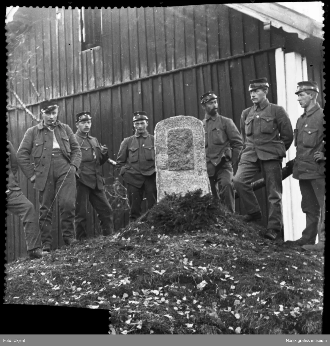 Soldater er samlet rundt en lav bautastein, antageligvis i området mellom Kongsvinger og Skotterud.