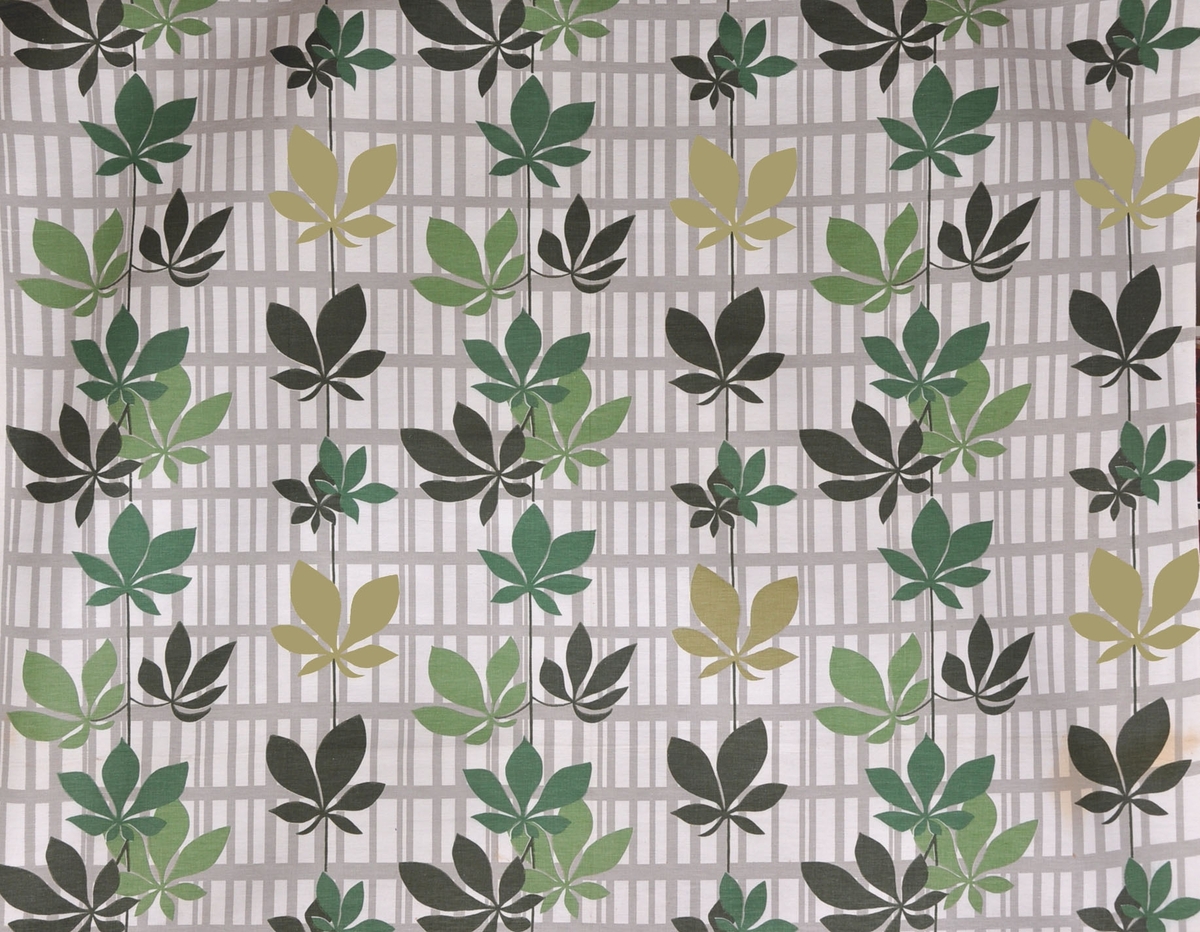 Bomullstyg  1960-tal,1st gardinlängd.
Tryckt mönster, grå-vit botten, bladverk i 4 olika gröna färger på ett rutigt bottenmönster.
Rapport 42 x 38,5 cm
Otvinnat garn