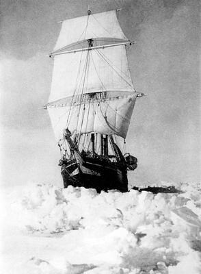 Bilde av et stort seilskip med seilene oppe. Skipet ligger i havet med snø rundt seg. Sorthvitt bilde.