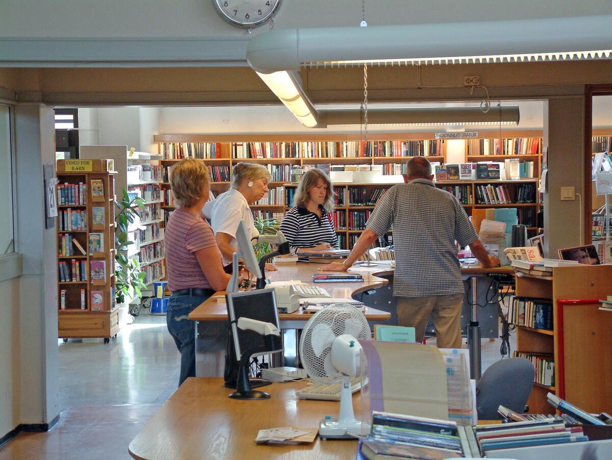 Biblioteksjef Ingard Gjerløw Hansen betjener brukere i skranken i hovedbiblioteket