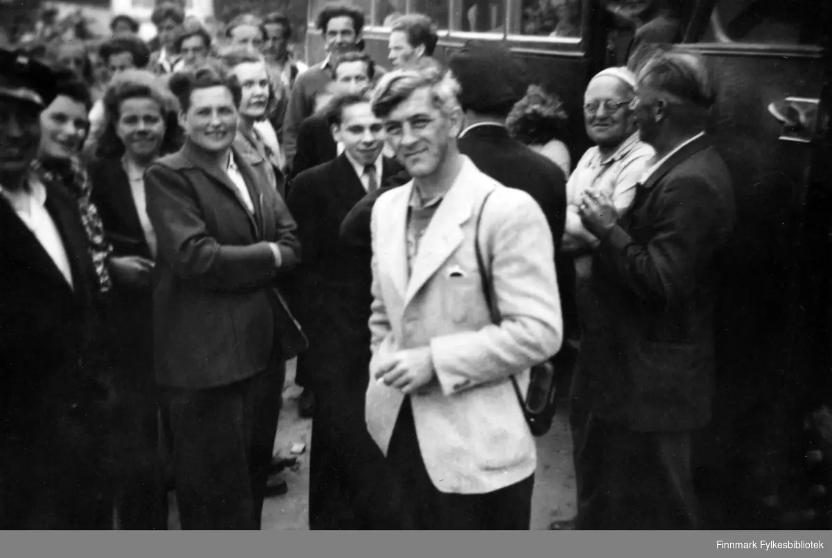Fra AUF-stevne i Åbo i Finland, 1949. Mannen i lys jakke er Lyder Brekkan fra Kirkenes. Mannen helt bak med stort hår, er Wilhelm Pettersen. Med på bildet er det mange mennesker. I bakgrunnen står det en buss