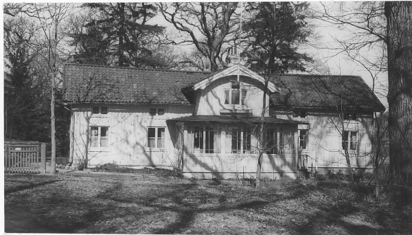 Fröknarna Sundströms villa på Särö med glasveranda och däröver en frontespis. Till vänster en grind.