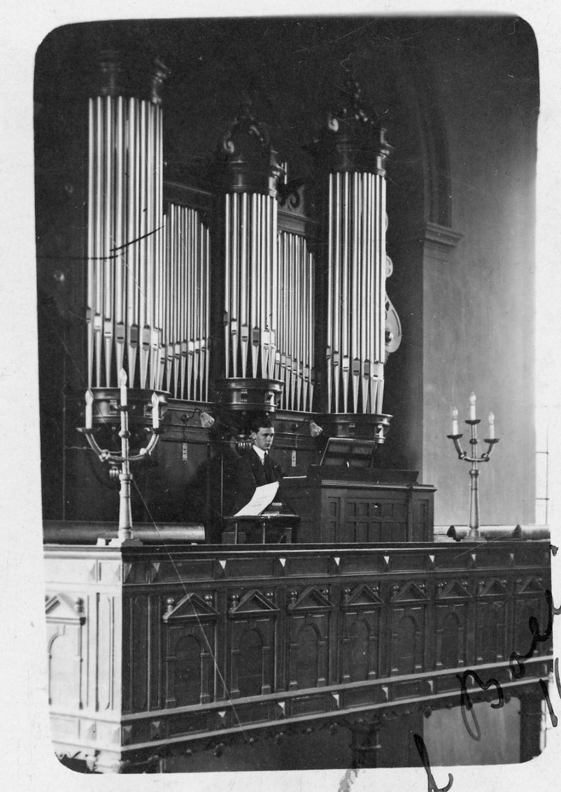En ung man spelar på kyrkorgeln i Gränna kyrka.