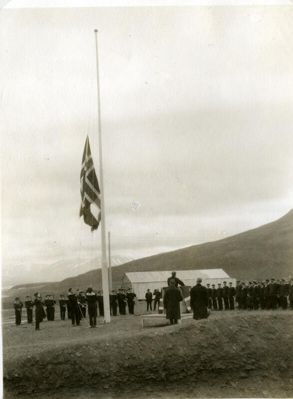 Bilde av norsk flagg som heises, med marinesoldater i bakgrunnen.