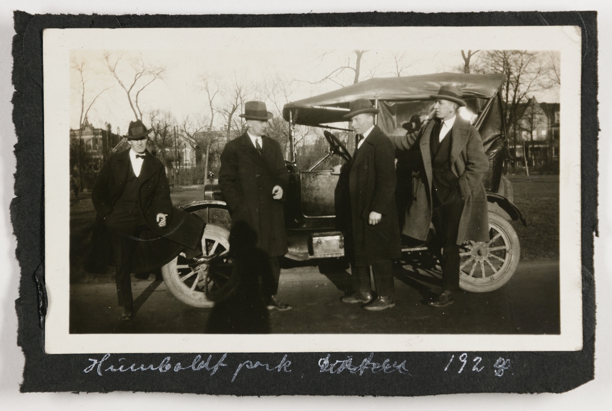Tre menn og Kalle (t.h.) ved en bil i Humboldt park, Chicago