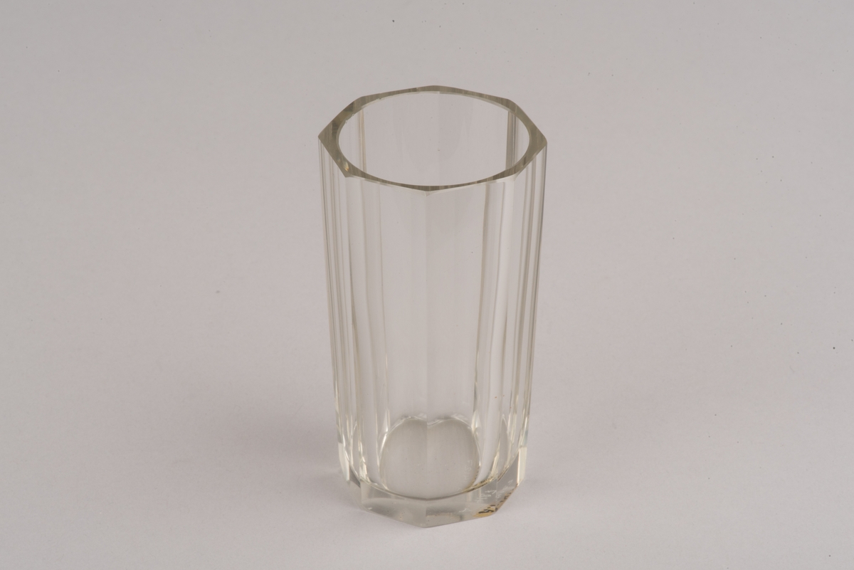 Facettslipat vattenglas.
Cylindrisk form med 8 slipade facetter från botten mot mynning. Glaset vidgas lite mot mynningen.
