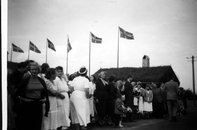 Personal med flera uppställda utanför Gyllene Uttern i väntan på kung Gustaf VI Adolf i samband med dennes Eriksgata. Flaggorna hissade.