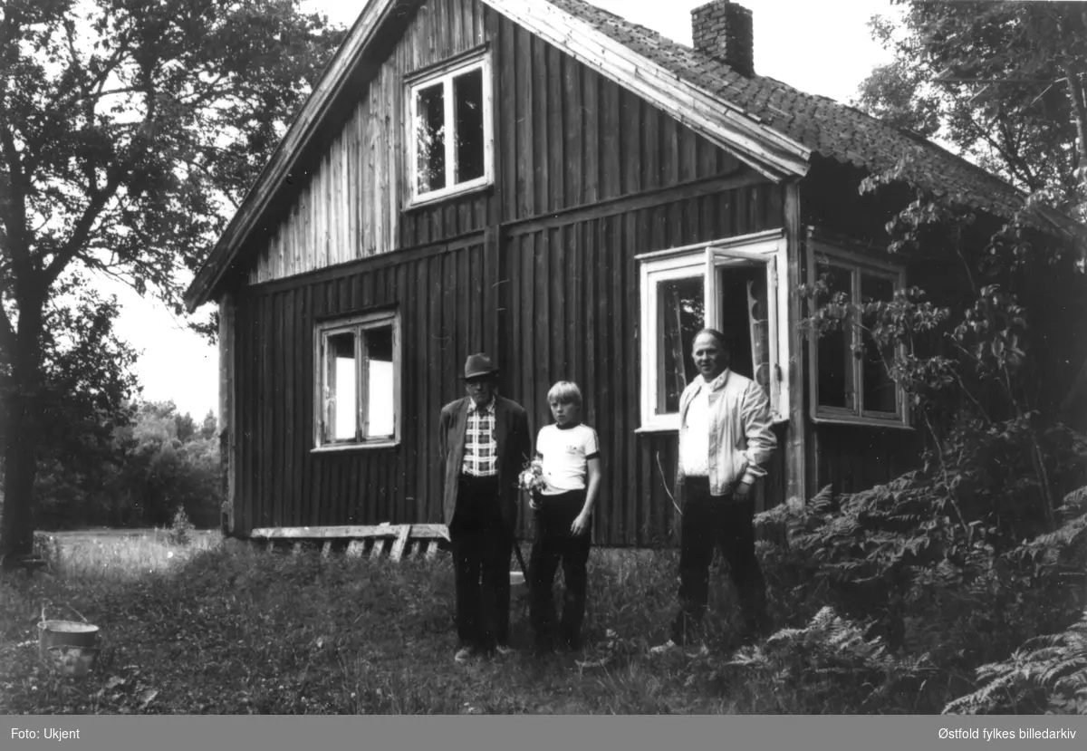 Våningshuset på gården Morthaugen øvre i Varteig fotografert ca. 1970. Fra venstre Bjarne Lunde,   Hytten, Helmer Lunde. Huset er nå (1993) borte.