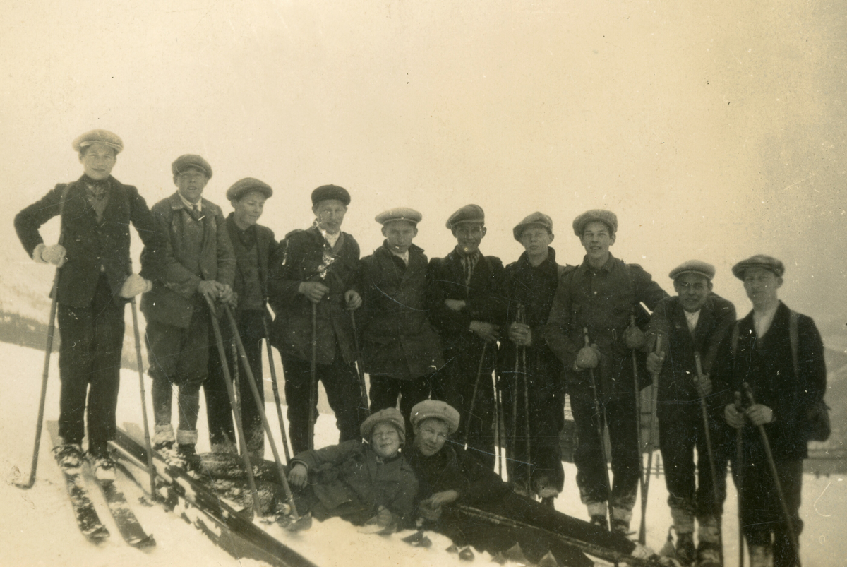 12 unge menn med ski poserar for fotografen.