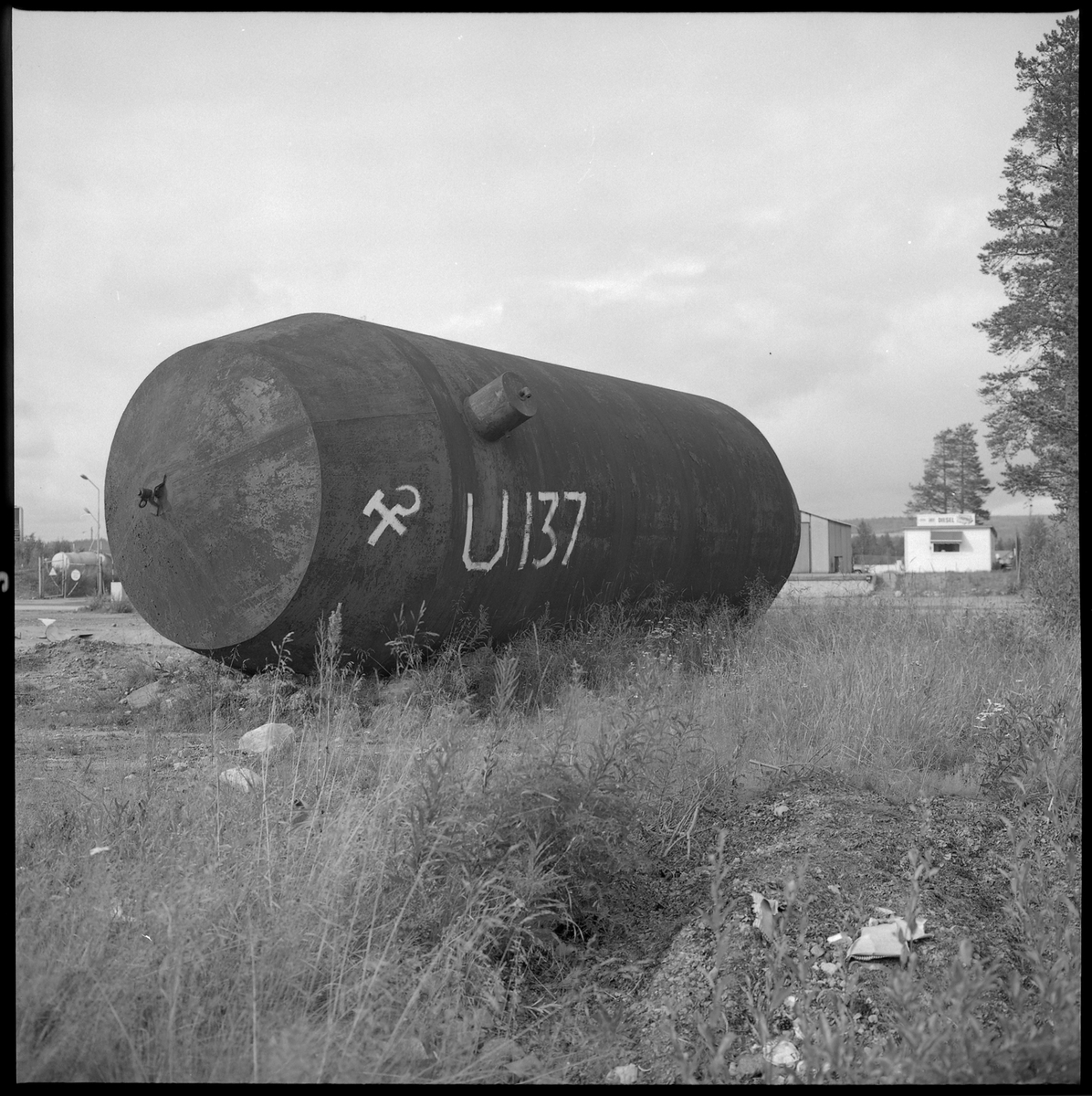Bilden föreställer en stor ståltank som är märkt med U-137 och Sovjetunionens stadsvapen. Bilden är tagen längs vägen mellan Gällivare och Malmberget.