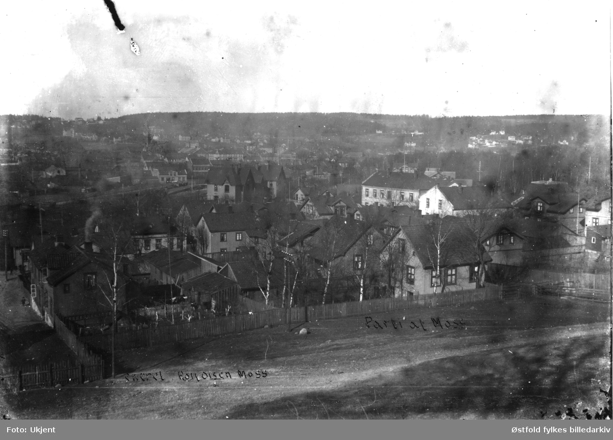 Oversiktsbilde fra Moss. På åpent jorde  i forgrunnen ble Fjordveien anlagt i 1938. Moss Jernbanestasjon ligger litt opp og litt til venstre for midten. Bildet tatt fra Kirkegårdområdet. Postkort.