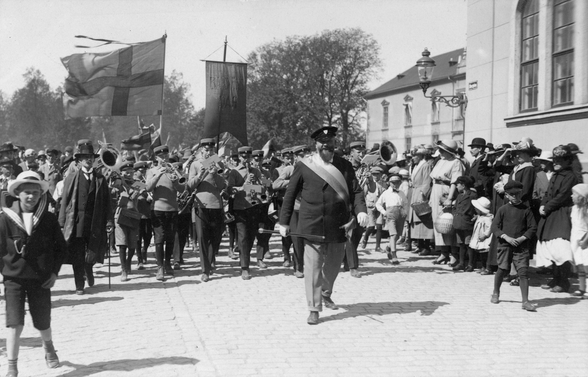 Motiv från firandet av Barnens dag i Linköping 1922. På bilden har flaggparaden nått Borggården. För musiken står Folkskolans musikkår. I täten ses Bror Edward Carlbaum.