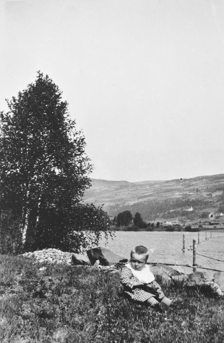Oppland, Øyer, Øyer, Jørgen Rybakken sitter på bakken med Lågen og Langlykkjevika i bakgrunn