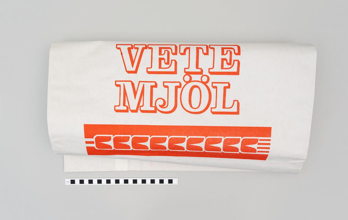 Oanvända förpackningar och säckar i papp för dinkel- och vetemjöl, mannagryn och groddar från När-Laus Valskvarn AB. 
 
Åtta förpackningar för produkter av dinkel; 
Helkorn 1,2 kg. Beige påse, tryckt. Blank yta. 
Mannagryn 1 kg. Grå påse, tryckt. 
Mjöl 1 kg. Beige påse, tryckt. Matt yta.
Groddar med kli från dinkel, 500 g. Vit påse, vit etikett. 
Skiktat Fullkorn, 2 kg. Vit påse, vit etikett. 
Kross, 5 kg. Vit påse, vit etikett. 
Fullkorn, 5 kg. Vit påse, vit etikett. 
Fullkorn, 5 kg. Brun påse, vit etikett. 

Tre tryckta förpackningar illustrerade med ax; 
Extra Kärn Vetemjöl, 2 kg. Vit påse, design och text i rött och gult.
Extra Kärn Vetemjöl, 5 kg netto. Vit påse, design och text i rött och gult.
Prima Rågskikt 5 kg netto. Vit påse, design och text i blått och gult.

En större pappersförpackning; Extra Kärnvetemjöl, 3 * 5 kg. Brun påse, röd text. 

En mindre säck; Vetemjöl, 25 kg. Vit säck, röd text. Illustrerad med bård av stiliserade veteax.  

Två större säckar för utsäde; 
Fälkontrollerat Utsäde. Vit säck, gul text. Gula bårder längs med långsidorna på säckens framsida. 
Hemodlat Utsäde Från Bygdekvarnen, Betat. Brun säck, svart text. Rutor med svart bård, gul bakgrund och svart text.
