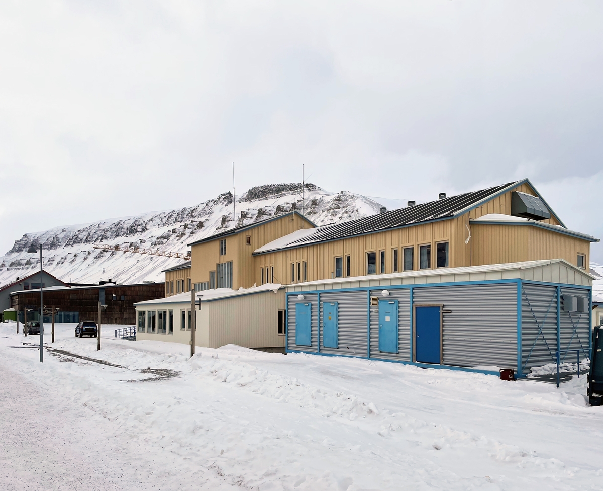 På plassen foran hovedinngangen står "Gruvearbeideren" av Kristian Kvakland. Skulpturen viser en gruvearbeider i liggende borestilling i en lav strosse. Kvakland var opptatt av at verket skulle formidle et mest mulig korrekt bilde av gruvearbeidet, og han besøkte blant annet Gruve 7 i Longyearbyen og Svalbardmuseet, hvor en tidligere gruvearbeider demonstrerte ulike borestillinger.

"Gruvearbeideren" er laget i utskåret furu og Iddefjordsgranitt, og står på en to meter høy sokkel i laminert furu. Materialenes røffe uttrykk speiler omgivelsene og bærer sterkt preg av stedets lokale historie.