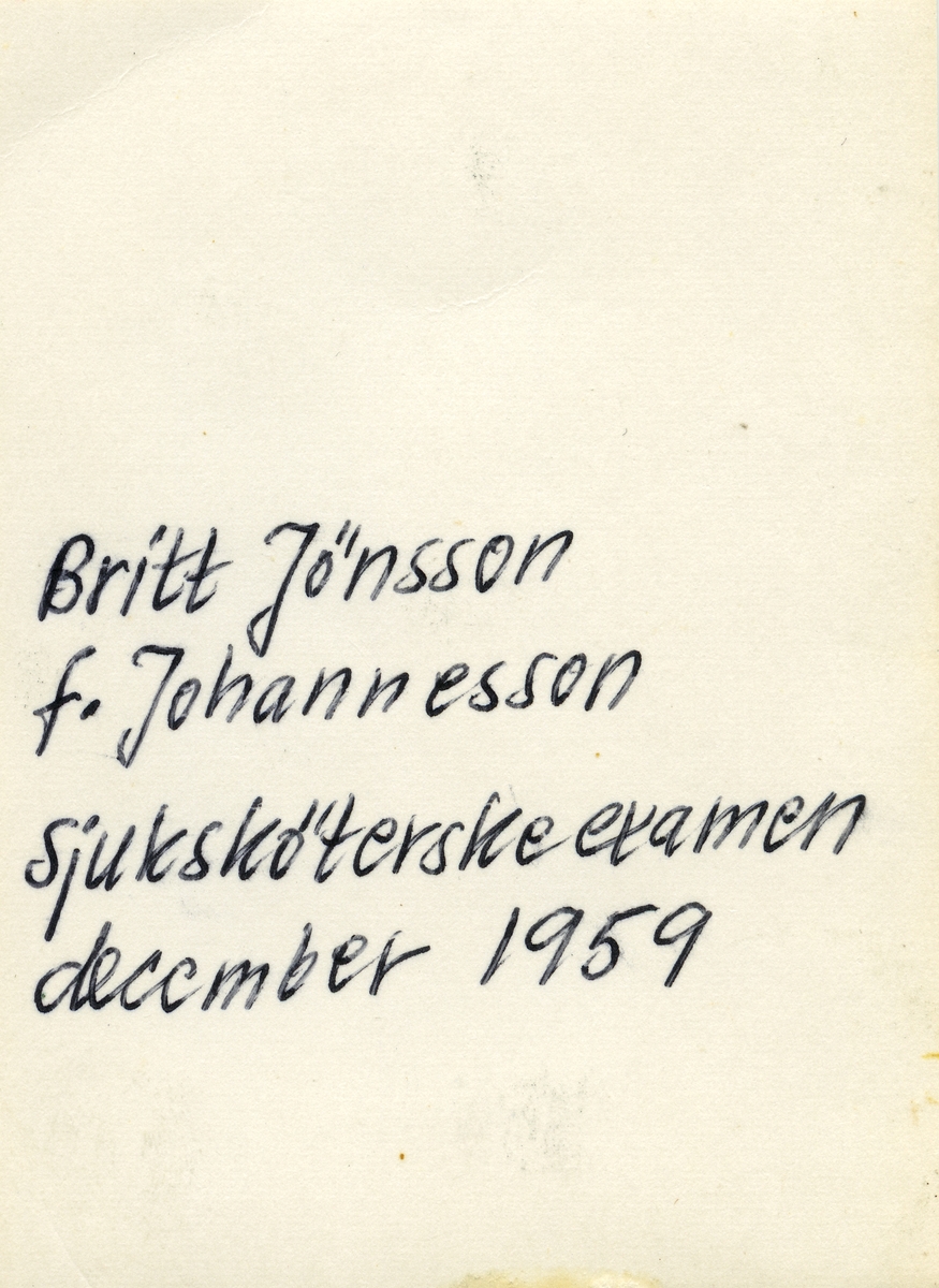 Bröstbild av Britt-Inger Johannesson, klädd i högtidsdräkt i samband med sjuksköterskeexamen vid Jönköpings läns landstings sjuksköterskeskola i december 1959.

Text på fotografiets baksida: "Britt Jönsson f. Johannesson sjuksköterskeexamen december 1959".