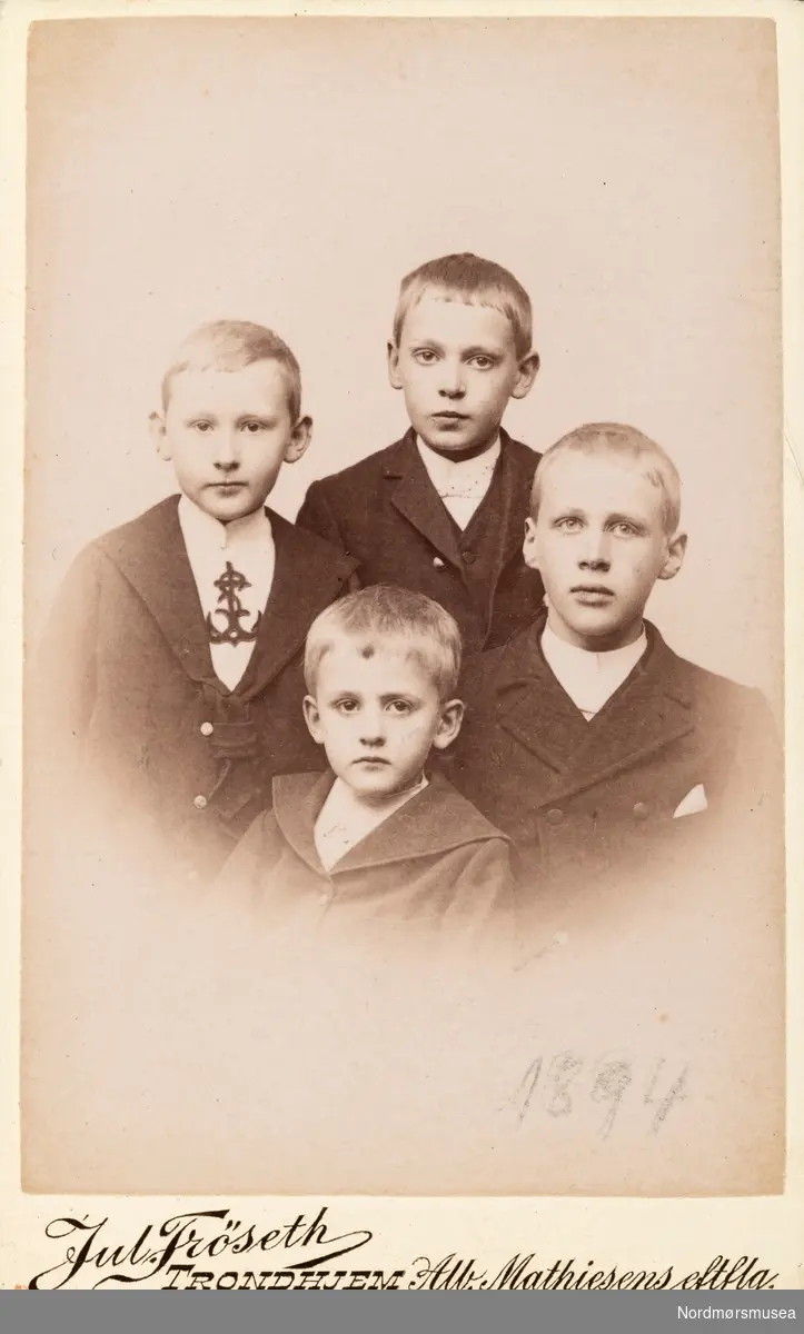 Visittkortfotografi av fire unge gutter. Trolig med tilknytning tili familien/slekten Werring i Kristiansund. Bildet har påført dato "Mai 1894" på baksiden, i tillegg til årstallet på fremsiden.