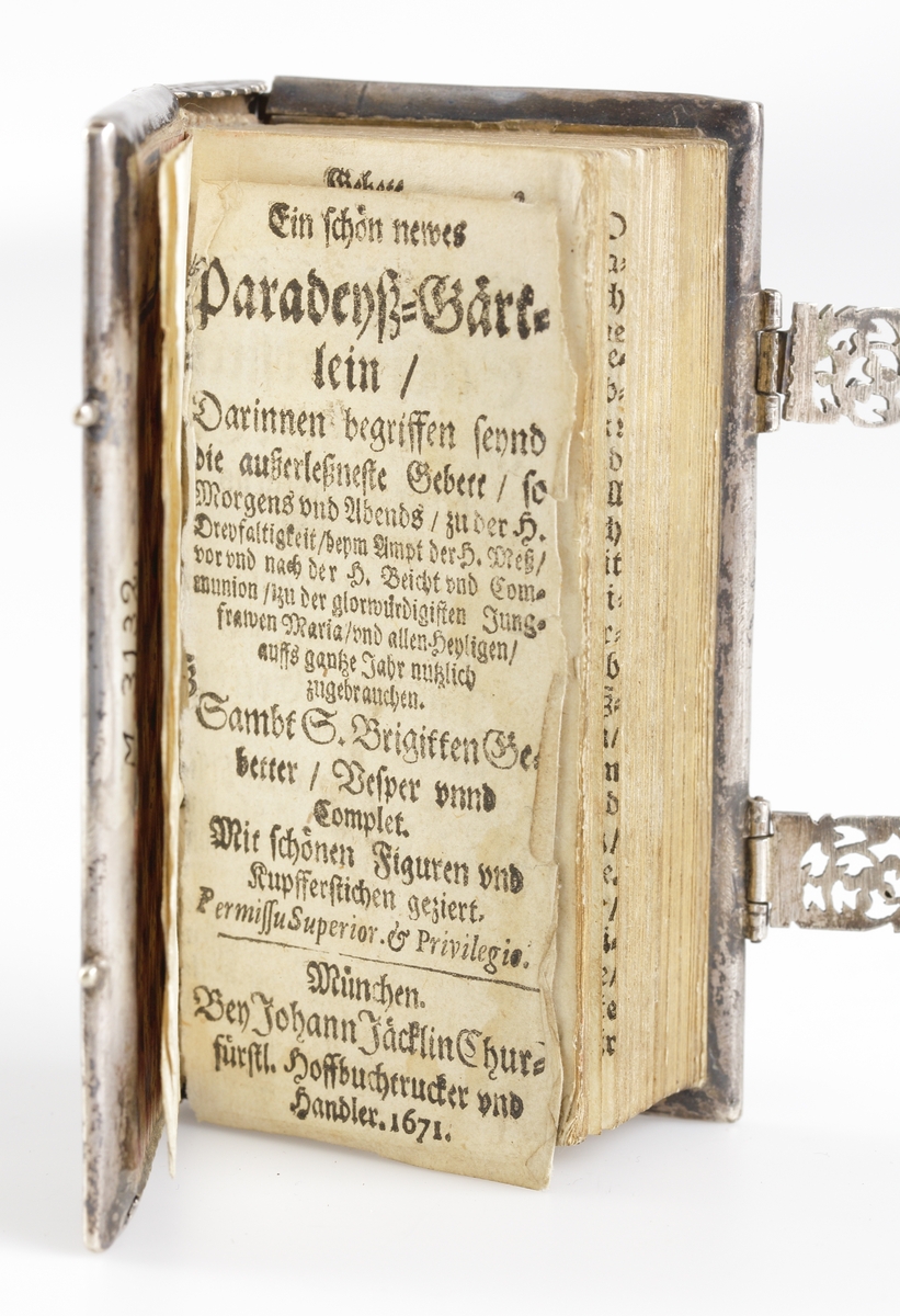 Ein schön newes Paradeysz-Gärtlein, München. Johann Jäcklin 1671. Bok på tyska på 332 sidor. Pärmen i genombrutet präktigt arbetat silverband. På framsidan oval bild med Maria och kristusbarnet. På baksidan oval bild med en mansperson i fullfigur. På ryggen en oval bild med en blomma. I guldsnitt. Silverspänne som som knäpper igen boken varav det ena trasigt.