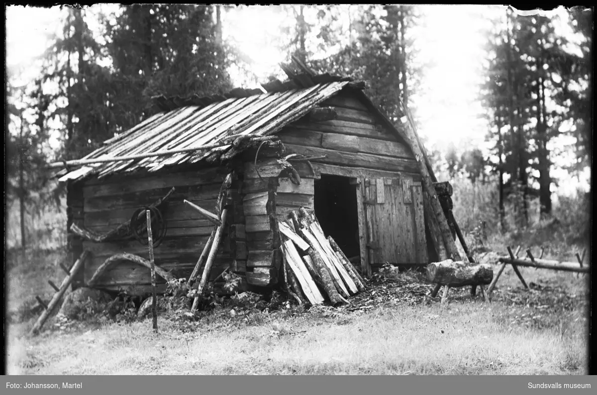 En liten timmerbyggnad med brädtak som var en samfälld sädestork, även kallad bastu, som fanns på Jonas Lindqvists gård i Norrfjolsta.