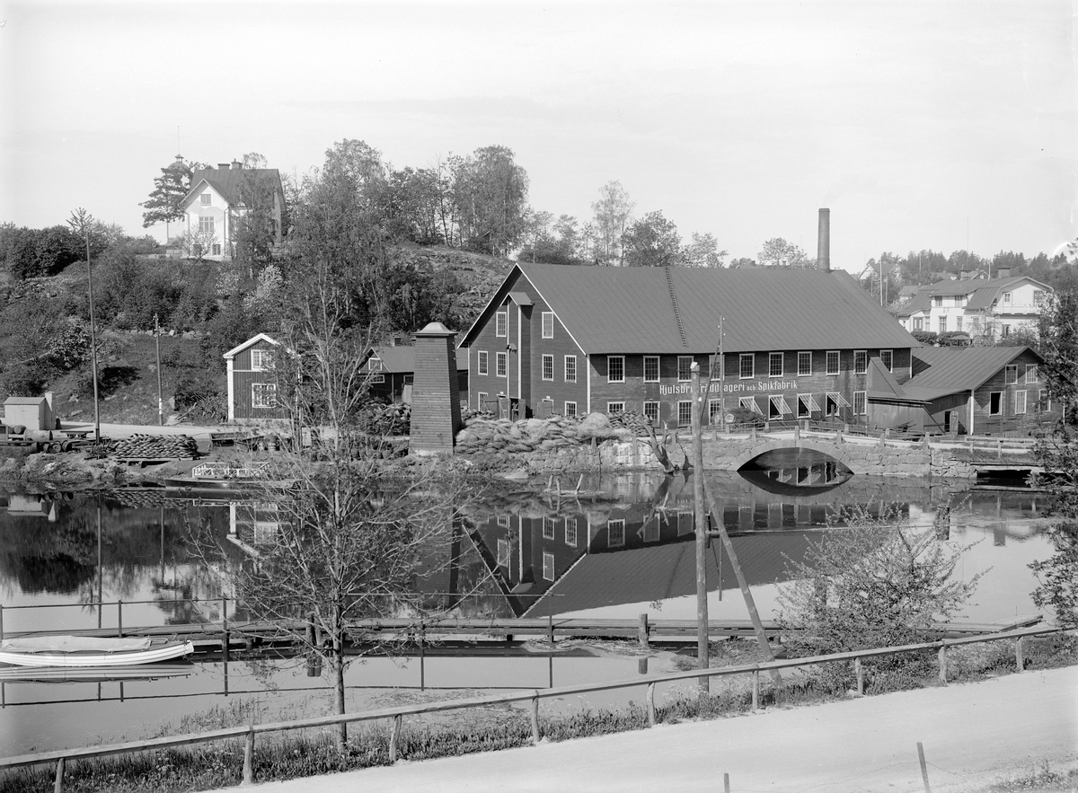 Anläggningen vid Hjulsbro Tråddrageri- och Spikfabriks AB som den tog sig ut kort före den ödelades i en brand 1930. Fabriksbyggnaden hade uppförts vid företagets start 1907 och ersattes efter branden av en för verksamheten mer anpassad industribyggnad.