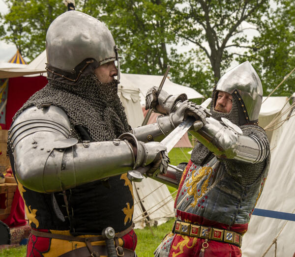 To riddere i platerustning i kamp med sverd